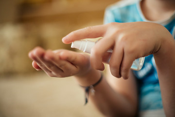 Obraz na płótnie Canvas sanitizer in hands of child. Hand treatment is disinfection tool. Destroying viruses from surface of skin. Safety at risk of contracting coronavirus.