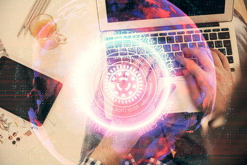 Fototapeta na wymiar Double exposure of man's hands typing over computer keyboard and tech theme hologram drawing. Top view. Technology concept.