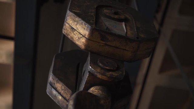 Big hook of tower crane holds metal chain 