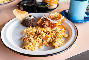 Desayuno de huevos revueltos a la mexicana con frijoles negros y chilaquiles