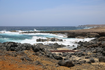 Fototapeta na wymiar North Eastern shoreline with volcanic rocks and crushing waves in Aruba