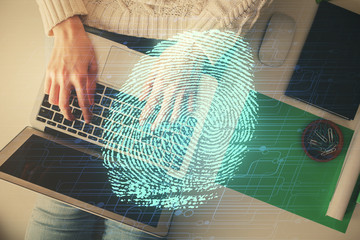 Double exposure of woman hands working on computer and fingerprint hologram drawing. Top View....