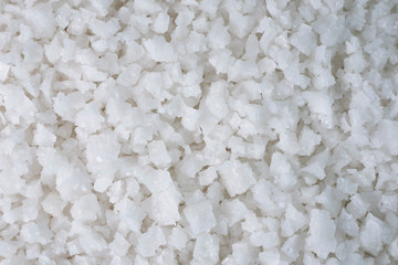 Background of sea salt, grains of salt crystals production. Heap of coarse salt
