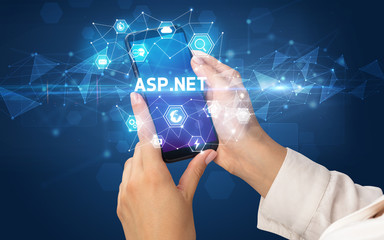 Female hand holding smartphone with ASP.NET inscription, modern technology concept