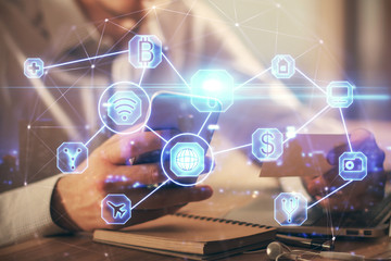 Double exposure of man's hands holding and using a phone and social network theme drawing.