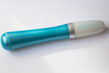A tool for manicure at home. Blue electric nail file with replaceable attachment with diamond coating on a white background close up