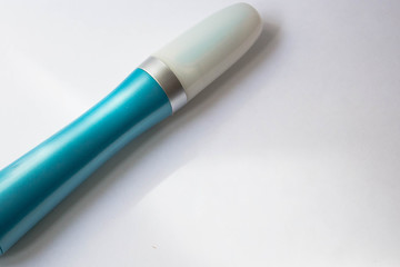 A tool for manicure at home. Blue electric nail file with replaceable attachment with diamond coating on a white background close up