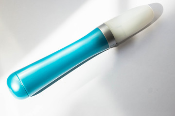 A tool for manicure at home. Blue electric nail file with replaceable attachment with diamond coating on a white background close up