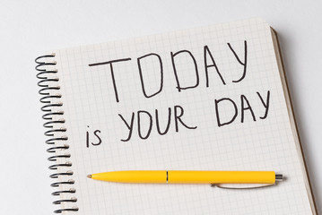 Motivational inscription in Notepad TODAY IS YOUR DAY. Close-up of notebooks and pen. Handwriting