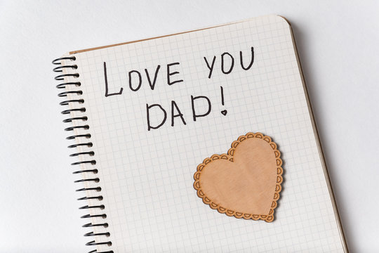 Cute inscription in notebook I LOVE YOU DAD. Close-up notepad and heart