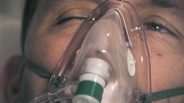 Young male struggling to breathe as he is recovering from COVID-19