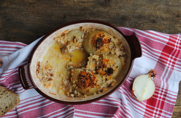 Ceramic Baking Dish with a few Roasted Stuffed Onions left after lunch. Top view.