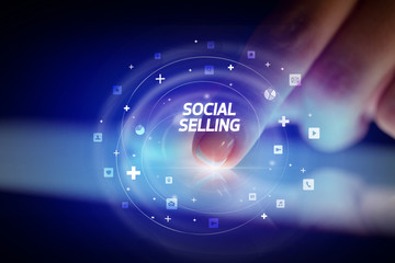 Finger touching tablet with social media icons and SOCIAL SELLING