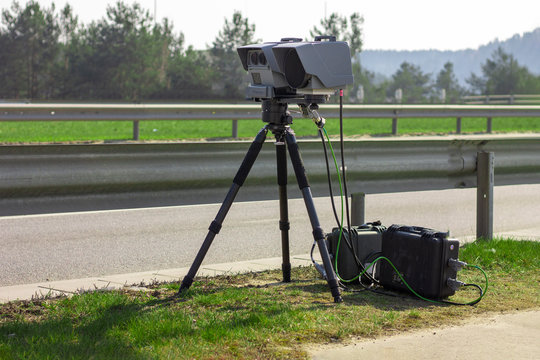 Vilnius, Lithuania - March 28, 2020: A mobile camera on a tripod standing near the road measures the speed of a passing vehicle