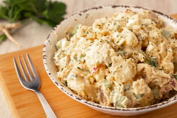 Potato Salad In Rustic Bowl On Wood Cutting Board