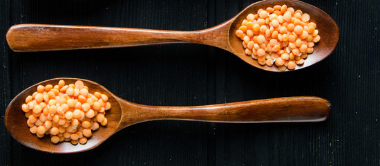 Spoons filled with uncooked lentil for soup