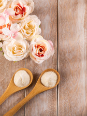 Hydrolyzed collagen powder with flowers on wooden background