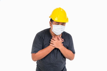 Male worker wearing a helmet and face mask and Coughing and pain and in studio on isolated white background. Concept of concern, protection and quarantine coronavirus (COVID-19).