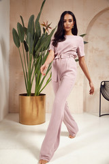 Beautiful sexy brunette woman tanned skin face cosmetic makeup wear pink suit pants for date walk office fashion clothes style collection interior room  sand color safari summer armchair palm boho.