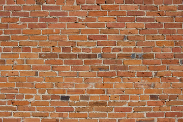 Shabby chic old brick wall texture background with deteriorating bricks in colors of red and orange