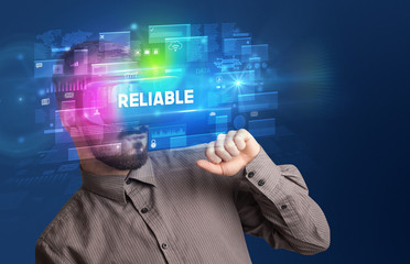Businessman looking through Virtual Reality glasses with RELIABLE inscription, innovative security concept