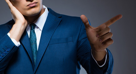 Businessman pressing virtual buttons on gray background