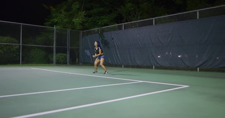 Woman playing tennis at night