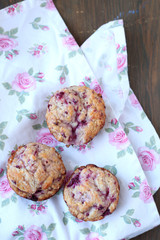 Fresh and warm homemade muffins on tablecloth