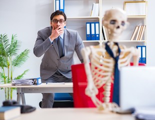 Businessman working with skeleton in office
