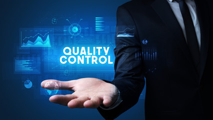 Hand of Businessman holding QUALITY CONTROL inscription, business success concept