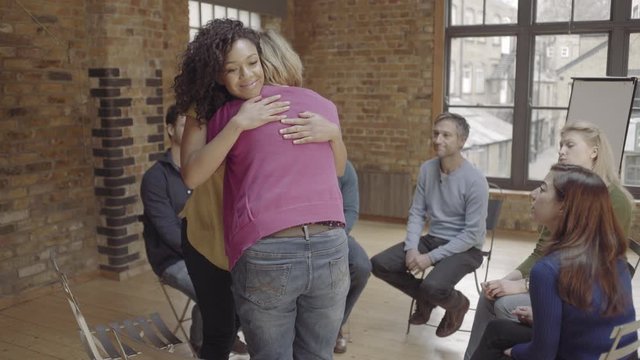 Women hugging in group therapy session