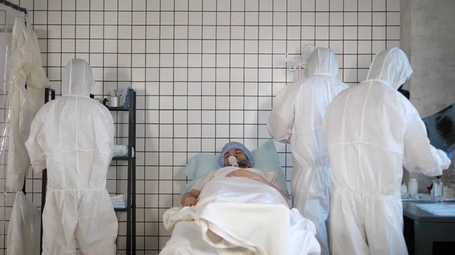 Doctors in Hazmat Sterile Suit around the patient in a hospital.