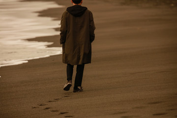 海岸を一人で歩く男性