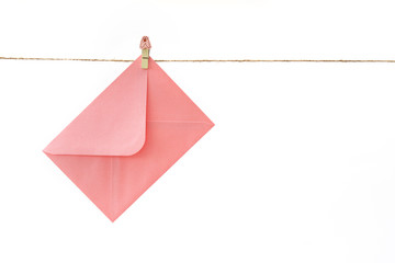 Pink envelope hanging on string isolated on white background