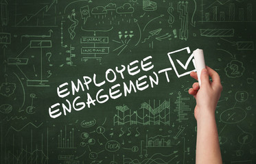 Hand drawing EMPLOYEE ENGAGEMENT inscription with white chalk on blackboard, new business concept