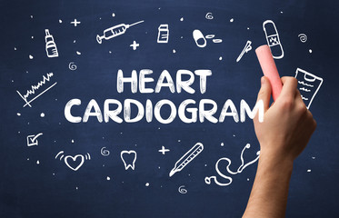 Hand drawing HEART CARDIOGRAM inscription with white chalk on blackboard, medical concept