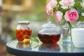 Tea in glass teapot. Romantic lunch in the garden. Summer time. Close up