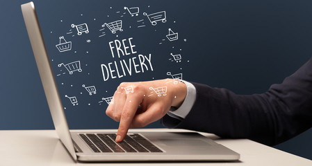 Businessman working on laptop with FREE DELIVERY inscription, online shopping concept