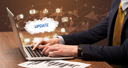 Businessman working on laptop with UPDATE inscription, modern technology concept