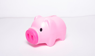 A pink piggy bank on the side of a white background