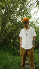 man with mustache and yellow cap and expansions looking at the ground
