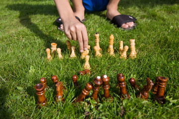 Chess pieces on the lawn on a sunny summer day. Chess game without a chessboard