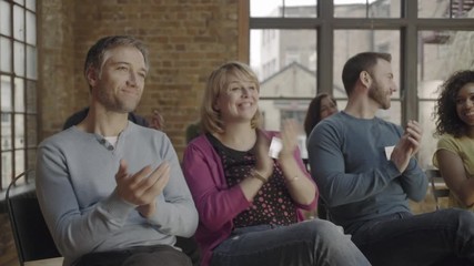 Group adults applauding speaker at event