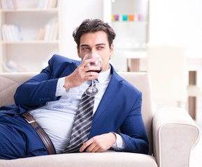Fototapeta premium Businessman drinking wine sitting at home