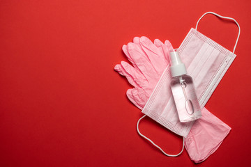 Sanitizer bottle, Medical surgical mask and lab gloves - Virus protection equipment on red background. COVID middle East respiratory syndrome coronavirus. corona virus disease 2019, COVID-19