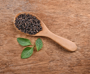 Black pepper and mint leafs on the wooden table
