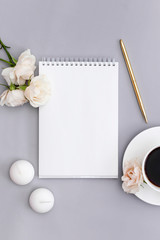 Blank paper and white coffee cup, pen, candle, flower on blue background