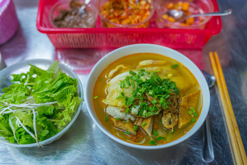 Bowl of delicious fish noodles soup served with vegetables