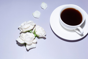 Cup of coffee and roses with hard light