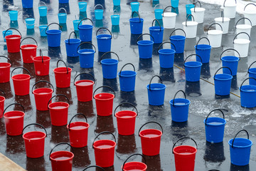 many colorful plastic buckets. water for dousing a person, a procedure for hardening the body